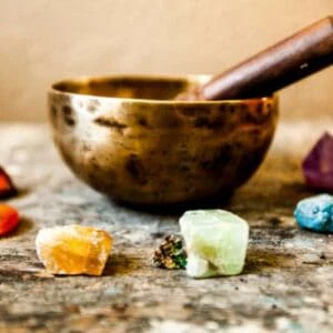 Chakra affirmation healing course - colourful chakra crystals with singing bowl used in energy aware practices and meditation