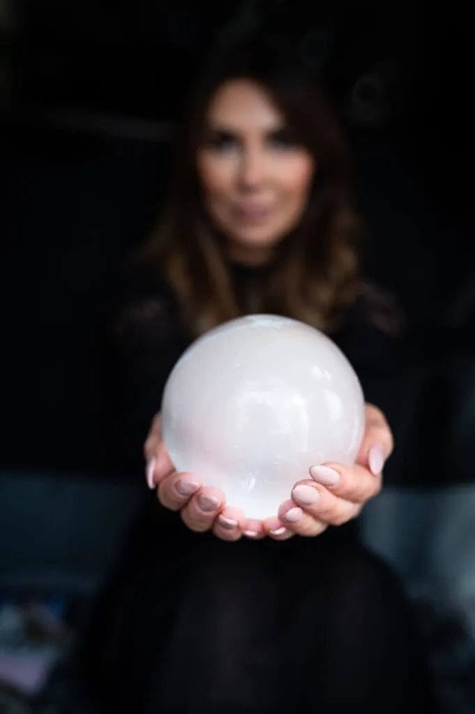 Anne-Marie, owner of Soul Awakening Academy professional image holding a crystal sphere, representing chakra healing, spiritual coaching, and energy work.