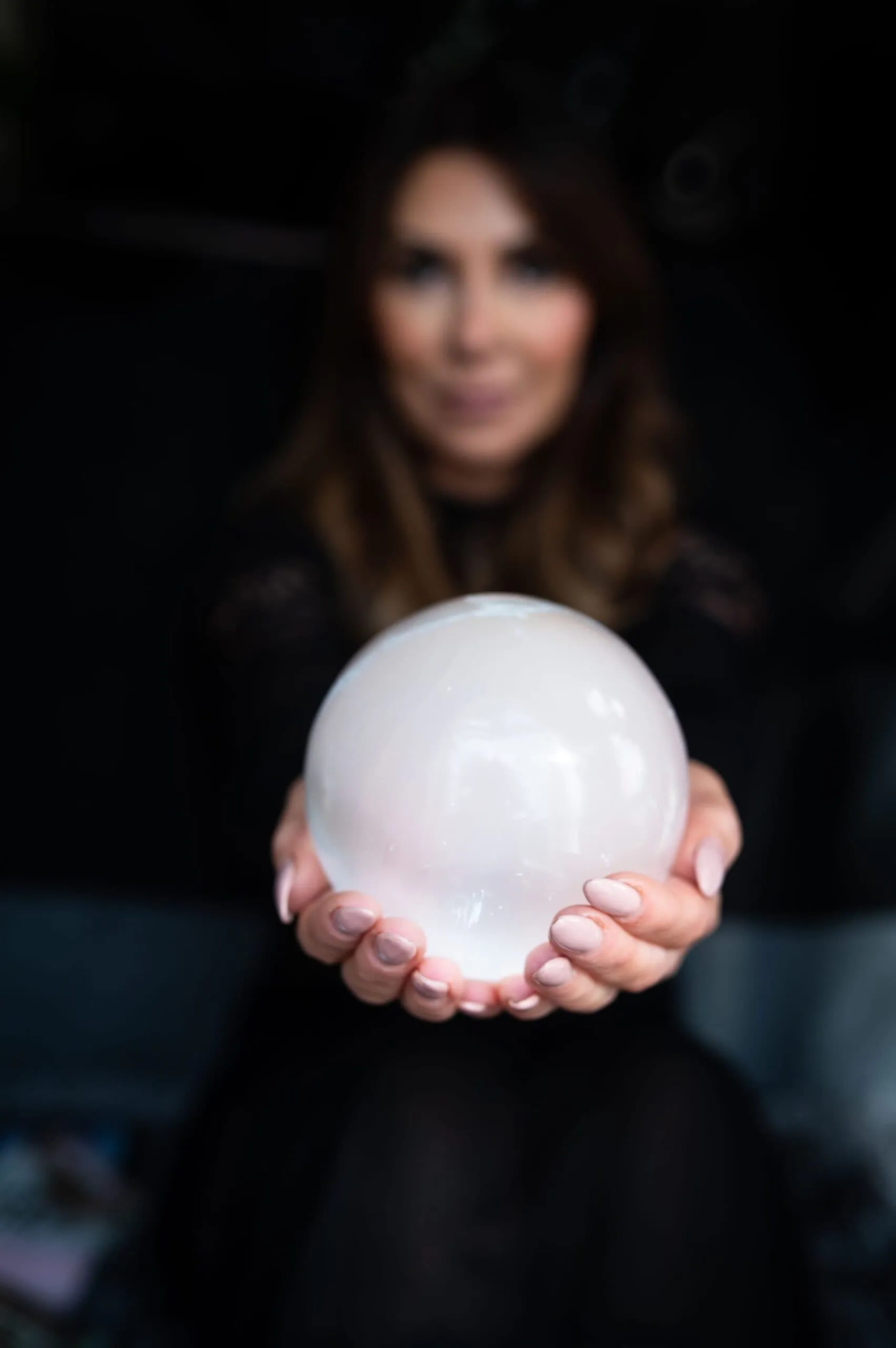 Anne-Marie, owner of Soul Awakening Academy professional image holding a crystal sphere, representing chakra healing, spiritual coaching, and energy work.