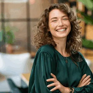 Smiling woman appearing calm and confident after Minfulness-based cognitive coaching session, symbolising self-awareness and emotional balance.